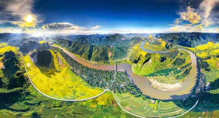 Aerial view of Gianh River winding through green mountains and rice fields in Quang Binh, Vietnam